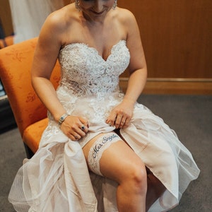 Wedding Garter Bride sitting on chair showing the fit of the garter on her leg.