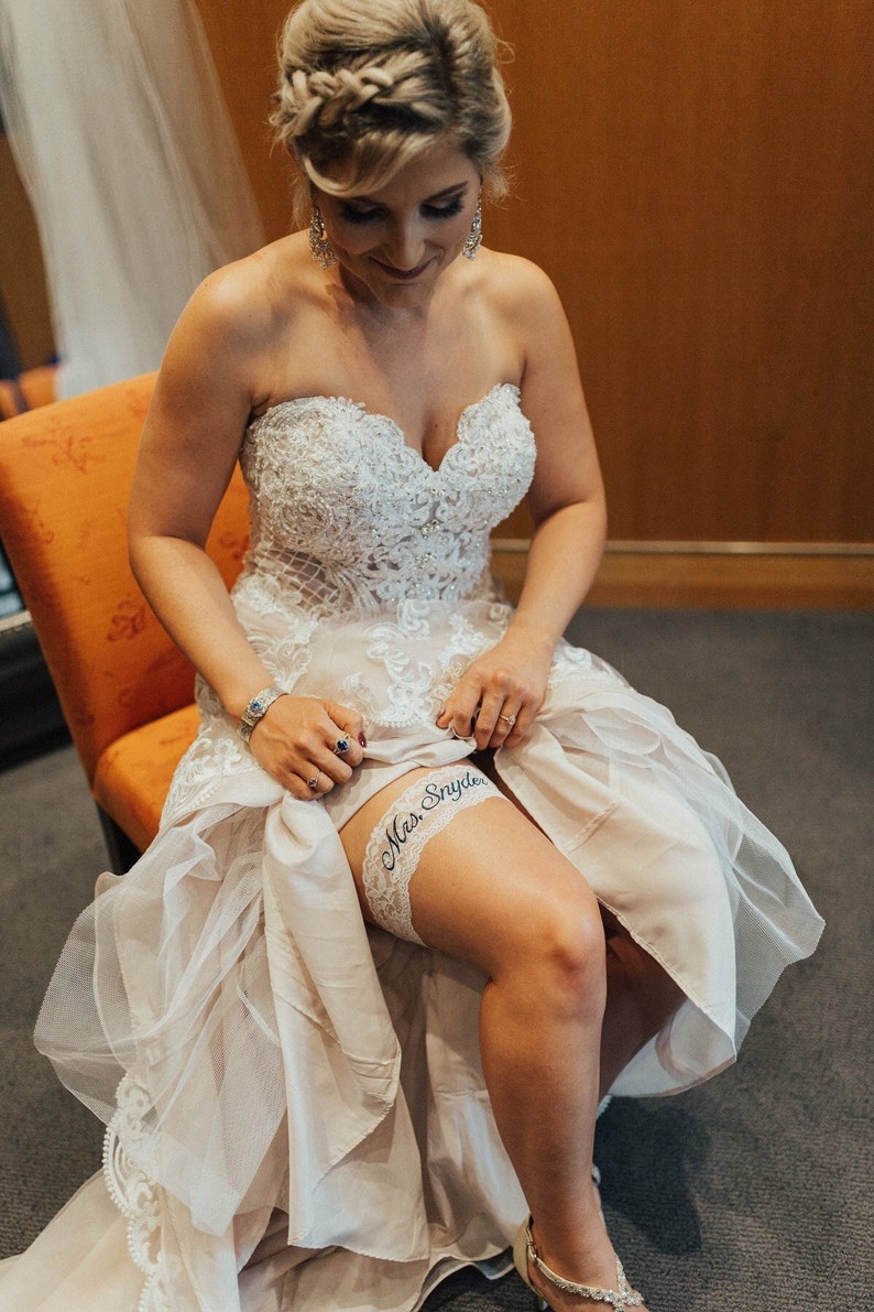 Wedding Garter Bride sitting on chair showing the fit of the garter on her leg.