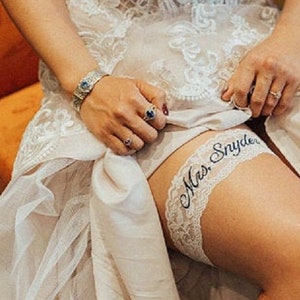 Wedding Garter Bride sitting on chair showing the fit of the garter on her leg.