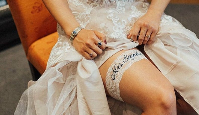 Wedding Garter Bride sitting on chair showing the fit of the garter on her leg.