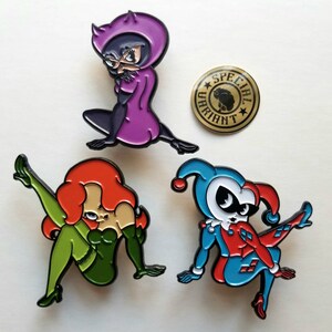 Puede incluir: Cuatro pines de esmalte con personajes de dibujos animados. Un gato morado con una m&aacute;scara negra, una mujer verde y roja con cabello rojo, una mujer roja y azul con un sombrero de buf&oacute;n y un pin dorado con el texto "Special Variant".