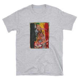 K&ouml;nnte beinhalten: Ein graues T-Shirt mit einem bunten Bild von Bob Marley, der Gitarre spielt. Das Bild ist in einem schwarzen Rahmen.