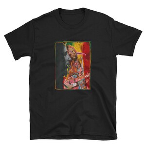 K&ouml;nnte beinhalten: Schwarzes T-Shirt mit einem bunten Bild von Bob Marley, der Gitarre spielt. Das Bild ist von einem gelben Rahmen umgeben.