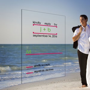 May include: A wedding invitation with the text "kindly reply by j+b september 14, 2016." The invitation also includes options to accept or decline. A couple stands on a beach in the background.