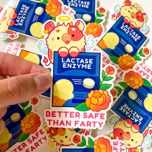 May include: A set of colorful stickers featuring a cartoon cow with angel wings and the text "Lactase Enzyme" and "Better Safe Than Farty". The stickers are designed for use on water bottles, laptops, and other surfaces.