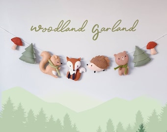 May include: Woodland garland with felt animals including a fox, squirrel, hedgehog, bear, and trees. The garland is strung with a white string.