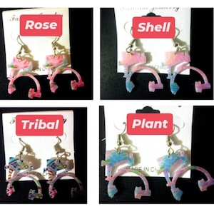 May include: Four pairs of dangle earrings with a rainbow-colored design. The earrings are labeled "Rose", "Shell", "Tribal", and "Plant".