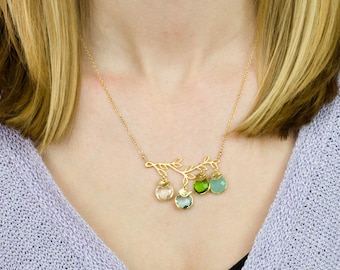 May include: A gold necklace with a delicate branch design and five dangling gemstone charms. The charms are in shades of green, blue, and pink.