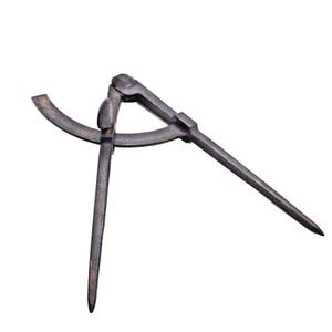 May include: An antique dark metal divider tool, used for measuring or transferring distances. The tool has two pointed legs connected by a hinge, and a curved arm. The divider is set against a white background.