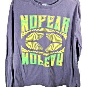 May include: A long-sleeved, dark gray t-shirt with the words "NO FEAR" and "MOLEYB" in a green and yellow design. The design features an oval shape with radiating lines. The shirt has a crew neck and a relaxed fit.