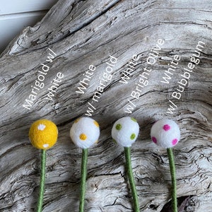 May include: Four felt ball stems with different colored balls and white polka dots. The colors are marigold yellow, white with yellow dots, white with green dots, and white with pink dots.