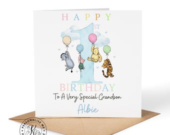 Puede incluir: Una tarjeta de felicitación cuadrada con un número uno grande de color azul claro e ilustraciones en acuarela de Igor, Piglet, Winnie the Pooh y Tigger sosteniendo globos de colores. El texto dice: HAPPY 1ST BIRTHDAY To A Very Special Grandson Albie.