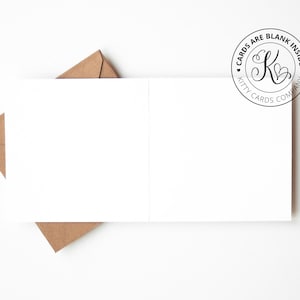 May include: A white folded greeting card with a blank interior, accompanied by a brown kraft paper envelope. A circular logo in the top right corner features the letter K with hearts and the text CARDS ARE BLANK INSIDE KITTY CARDS COMPANY.
