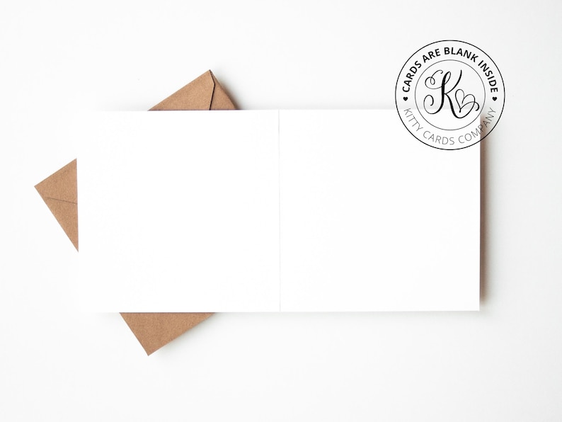 May include: A white folded greeting card with a blank interior, accompanied by a brown kraft paper envelope. A circular logo in the top right corner features the letter K with hearts and the text CARDS ARE BLANK INSIDE KITTY CARDS COMPANY.