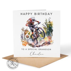 May include: A square greeting card featuring a watercolour illustration of a mountain biker mid-air. Text reads HAPPY BIRTHDAY, 16, TO A SPECIAL GRANDSON, and the name Charlie. The card is paired with a brown envelope on a white surface.