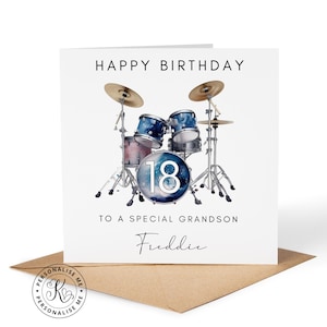 May include: A square white greeting card featuring a blue galaxy-patterned drum kit illustration with the number 18 on the bass drum. The text reads HAPPY BIRTHDAY, TO A SPECIAL GRANDSON, and the name Freddie in a black script font.