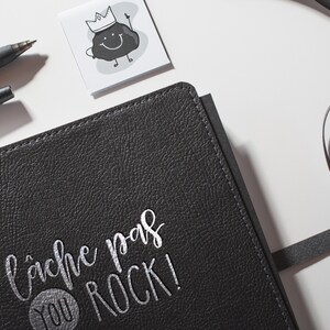Peut inclure: Journal en cuir noir avec inscription en argent "Cache pas you rock!"
