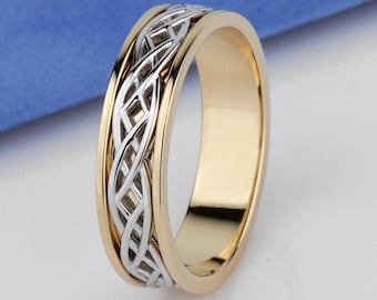 May include: A two-tone ring featuring a polished gold-colored band with a central silver-colored inlay. The silver inlay displays an intricate, openwork woven pattern that wraps around the circumference of the ring, contrasting with the smooth, solid gold-colored edges.