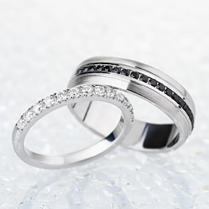 His and hers wedding bands with black and white diamonds. Gold wedding rings set.