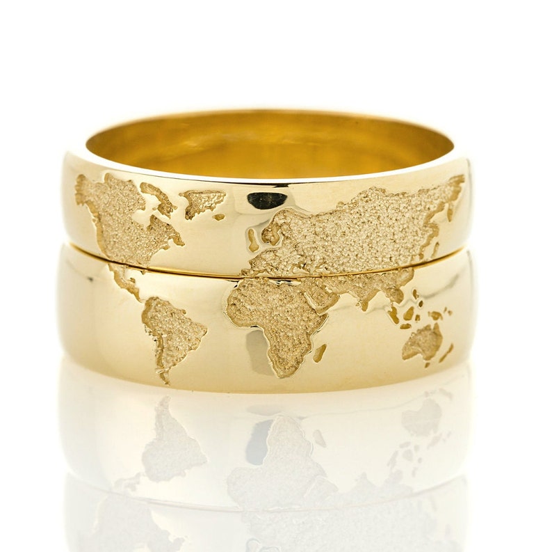 Gold wedding bands set with world map.