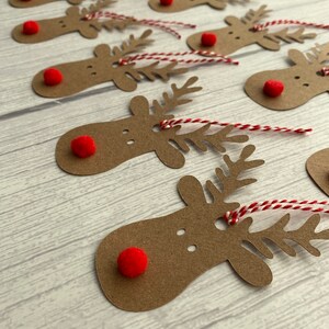 May include: A set of ten brown paper reindeer gift tags with red pom-poms for noses and red and white twine.