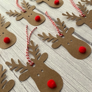May include: A set of eight brown paper reindeer gift tags with red pom-poms for noses and red and white twine.