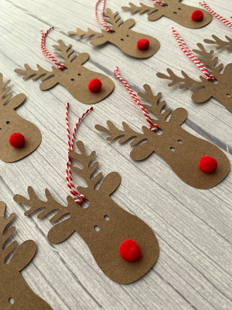 May include: A set of eight brown paper reindeer gift tags with red pom-poms for noses and red and white twine.