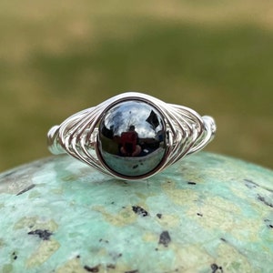 Peut inclure: Une bague en fil d'argent avec une pierre précieuse en hématite noire.
