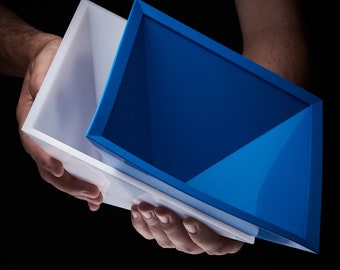 May include: Two nesting boxes, one white and one blue. The blue box is on top of the white box.