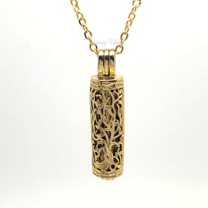 May include: Gold necklace featuring a tree of life pendant. The pendant is hollow and has a delicate, intricate design.