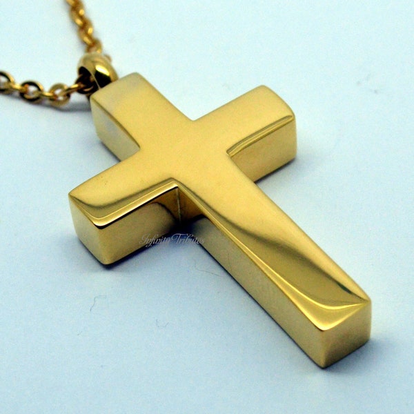 Puede incluir: Un collar con un colgante de cruz de oro. La cruz es gruesa y tiene un acabado brillante.