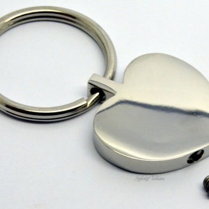 Puede incluir: Llavero de corazón plateado con tapa de rosca. El llavero tiene un pequeño anillo para llaves. El tornillo está incluido.