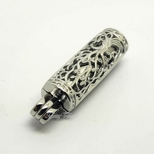 May include: Silver-toned metal cremation urn pendant with a detailed tree of life design. The urn has a threaded opening for adding ashes or other mementos.