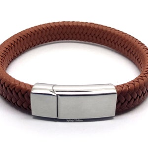 Op de afbeelding: Een bruin gevlochten leren armband met een zilveren magneetsluiting.