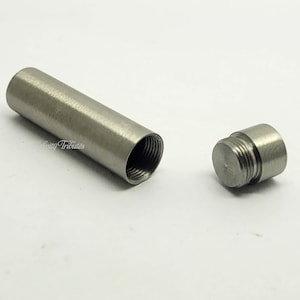 May include: A silver metal tube with a threaded cap. The tube is open at one end and has a threaded opening at the other end.