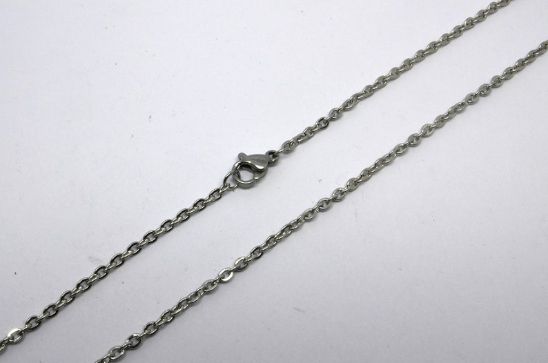 May include: A silver chain necklace with a lobster clasp.