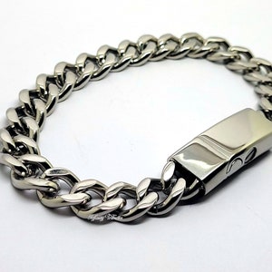 May include: A silver curb chain bracelet with a polished finish and a secure clasp.