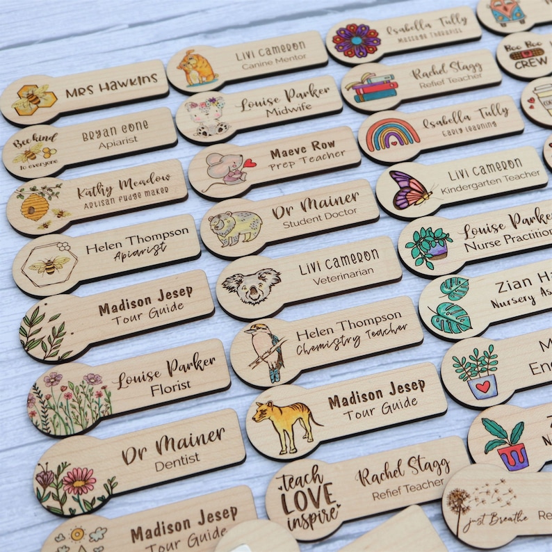 May include: Wooden name tags with various professions and illustrations. The tags feature names like "Mrs. Hawkins" and "Dr. Mainer," along with images of animals, flowers, and other designs. The text "Teach Love Inspire" is also visible.