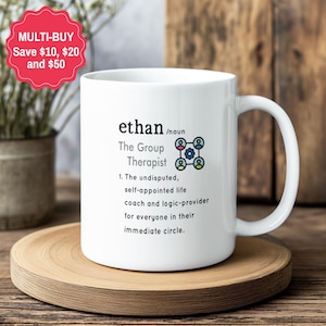 May include: A white ceramic mug featuring black text that defines the name Ethan as the group therapist, describing them as a self-appointed life coach and logic-provider for their circle, accompanied by a small icon of four connected people.