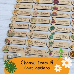 May include: Wooden name tags with various professions and illustrations, including a bee, koala, and rainbow. The text "Choose from 19 font options" is displayed in the image. The tags are rectangular with rounded ends and a magnetic clasp.