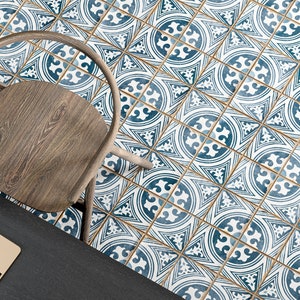 May include: A wooden chair with a dark brown seat sits on a tiled floor with a blue and white geometric pattern. The tiles have a gold accent.