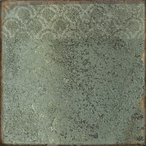 May include: A square ceramic tile with a weathered, textured surface in shades of sage green and dark gray. The top section features a faint, repeating scalloped pattern, while the edges show a dark, rusted brown border with a distressed finish.