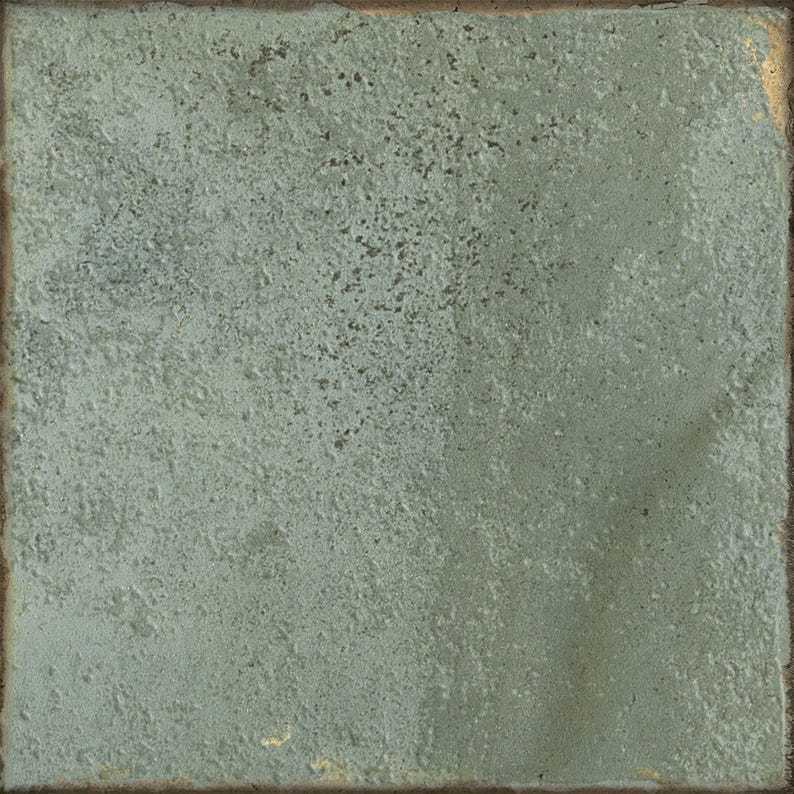 May include: A square ceramic tile with a textured, matte surface in a muted sage green color. The tile features a weathered, uneven finish with subtle variations in tone and a dark, rustic edge that frames the entire perimeter of the piece.