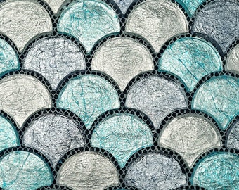 May include: A close-up of a mosaic tile pattern featuring a repeating design of overlapping, semi-circular shapes. The tiles are a mix of silver and teal blue with a textured, iridescent finish.