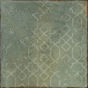 May include: A square tile with a textured, sage green surface featuring a faint, repeating geometric pattern of interlocking diamonds and elongated hexagons in a lighter, muted tone. The edges of the tile appear slightly worn and dark.