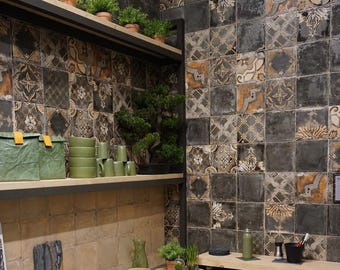 May include: A kitchen or bathroom with decorative tiles in shades of gray, brown, and beige. The tiles have intricate patterns. Shelves hold plants, green mugs, and other kitchenware. A bonsai tree is also visible.
