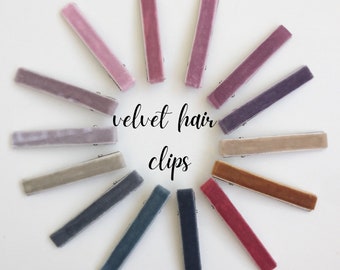May include: A set of 12 velvet hair clips in various colors, including purple, gray, brown, and blue. The clips are arranged in a circle on a white background. The text "velvet hair clips" is written in the center of the circle.