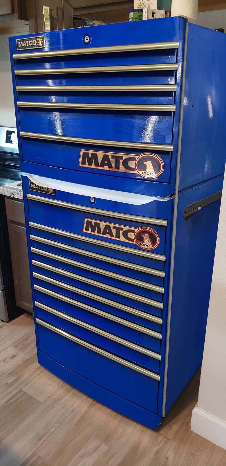 May include: A blue metal toolbox with multiple drawers. The toolbox has a silver handle and is labeled "MATCO TOOLS" on the front.