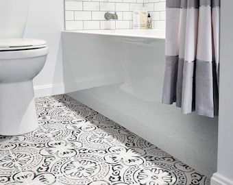 May include: A white bathroom with a white toilet, a white bathtub, and a shower curtain with gray and white stripes. The floor is tiled with black and white patterned tiles.