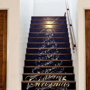 May include: A set of 10 Christmas-themed stair treads with a blue background and gold glitter. The treads feature a stylised Christmas tree with a star on top and the words "Merry Christmas and Happy New Year".